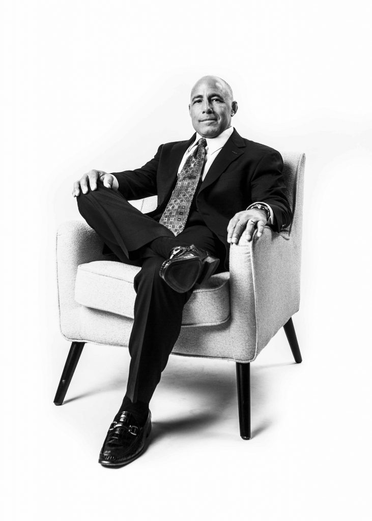 A man sitting in a chair wearing a suit and tie.